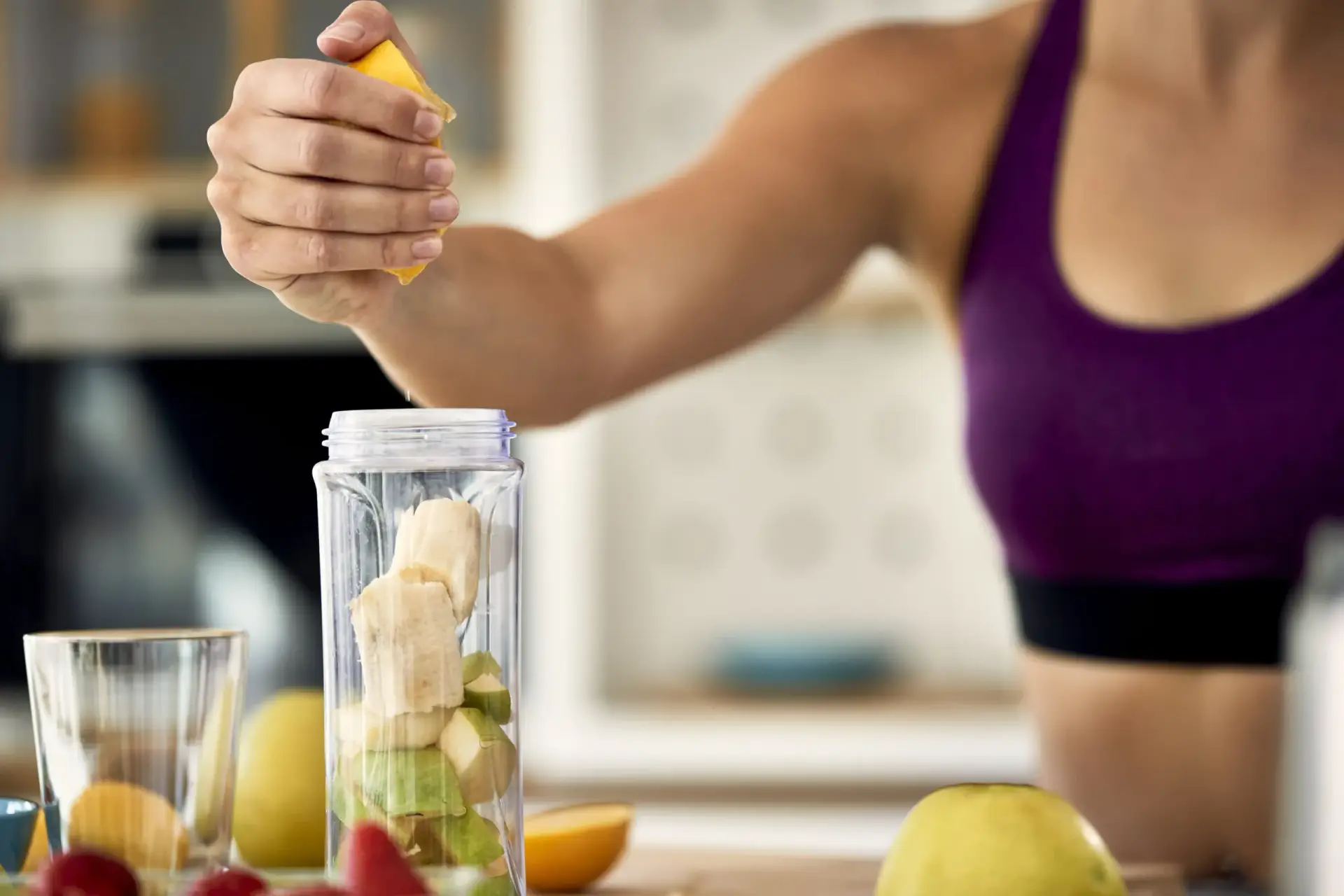 Mujer deportista preparando bebida nutritiva con limón para mejorar rendimiento en tenis - nutrición deportiva