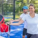 Entrenador enseñando pádel a principiantes en pista exterior - guía completa para empezar en pádel